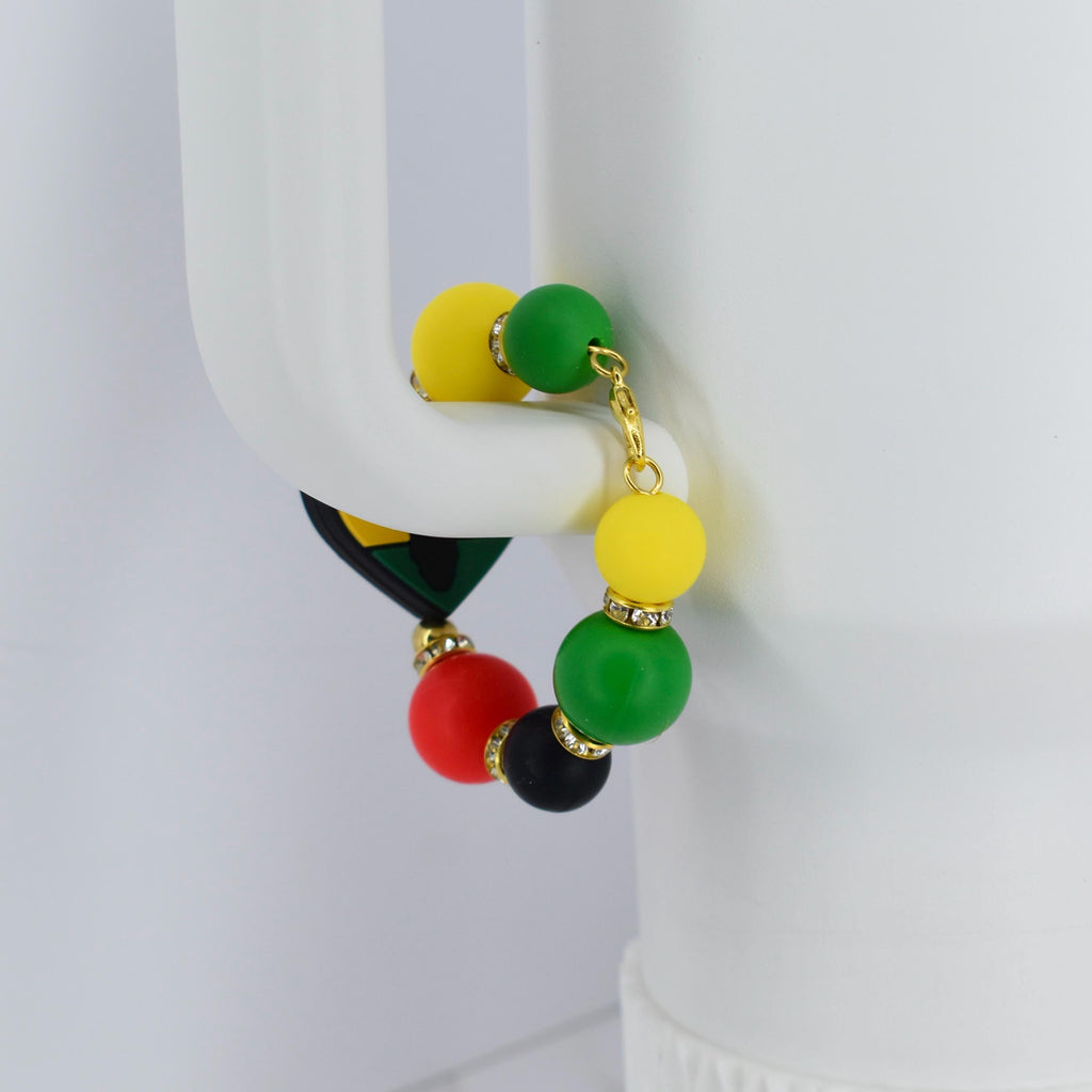 A colorful beaded bracelet featuring yellow, green, red, and black beads. The bracelet has gold-colored accents and a small charm with a geometric design. The beads are round and smooth, creating a vibrant accessory.