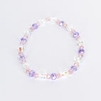 A delicate bracelet featuring a mix of clear, iridescent, and pastel-colored beads. The design incorporates oval and round beads in shades of pink and purple, creating a subtle, feminine accessory.