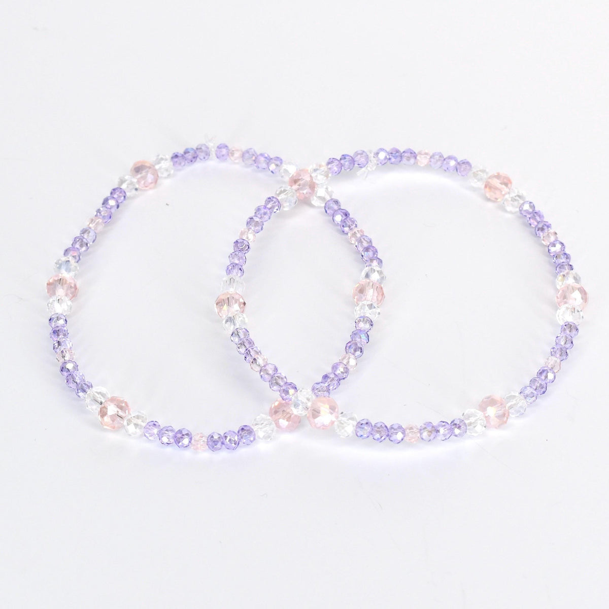 Two beaded bracelets. Each bracelet is a circle of small, light purple, clear, and pink beads. The bracelets are on a white background. The beads are strung together with a clear string.