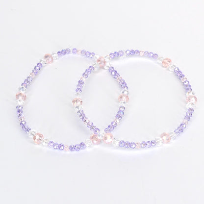 Two beaded bracelets. Each bracelet is a circle of small, light purple, clear, and pink beads. The bracelets are on a white background. The beads are strung together with a clear string.