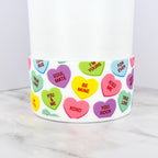 White tumbler boot with a colorful heart-shaped design. Each heart has a different message, including "Be Mine," "Kiss Me," and "Soul Mate." The tumbler is a fun and festive item.