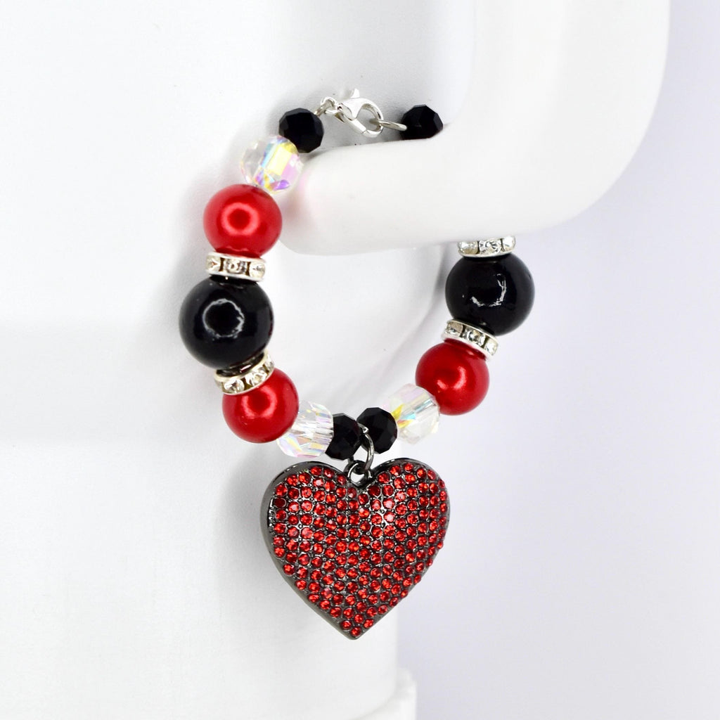 A beaded tumbler handle bracelet featuring red, black, and clear beads with silver accents. The bracelet has a heart-shaped pendant covered in red rhinestones. The clasp is silver.