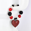 A beaded tumbler handle bracelet featuring red, black, and clear beads with silver accents. The bracelet has a heart-shaped pendant covered in red rhinestones. The clasp is silver.
