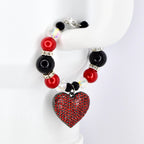 A beaded tumbler handle bracelet featuring red, black, and clear beads with silver accents. The bracelet has a heart-shaped pendant covered in red rhinestones. The clasp is silver.