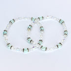 Two delicate bracelets with clear crystal beads and light blue pearl-like beads. The bracelets have silver-colored accents and are arranged in a figure-eight shape against a white background. The jewelry is likely for a special occasion.