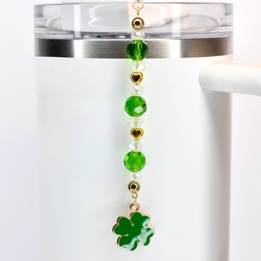 A green, crystal and gold beaded tumbler straw charm with a green shamrock charm at the bottom.