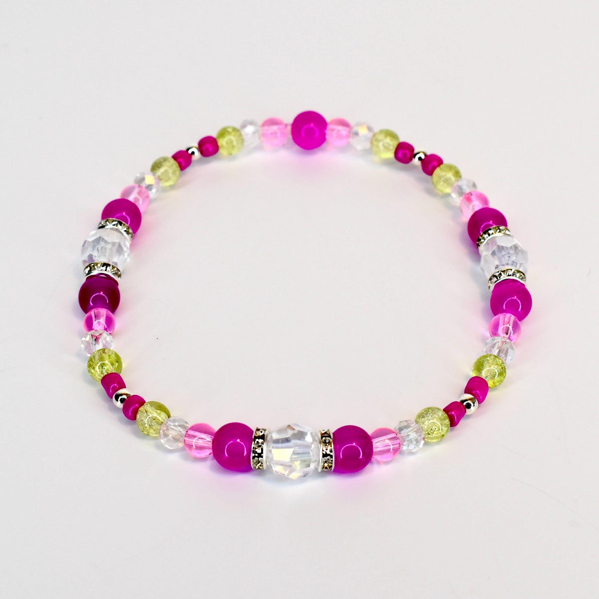 A beaded bracelet featuring a mix of pink, clear, and light green beads. The bracelet includes larger, round magenta beads, clear faceted beads, and smaller green and clear beads. Silver-colored spacers are interspersed throughout.