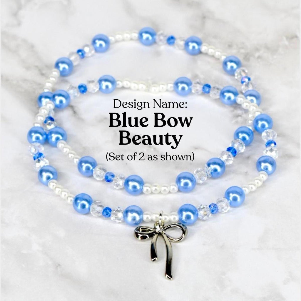 Two beaded bracelets with blue and white beads, and a silver bow charm. The necklaces are labeled "Blue Bow Beauty" and are displayed on a marble surface. The beads are a mix of round and crystal-like shapes.