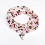 A set of five beaded bracelets with a speckled, matte finish. The bracelets are in shades of light pink, purple, and clear.