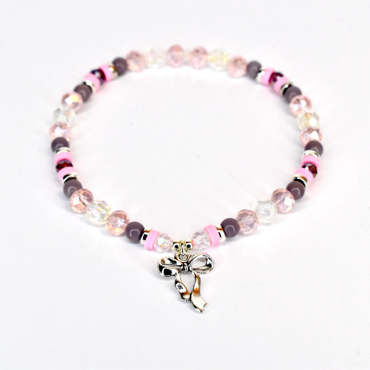 A beaded bracelet featuring a silver bow charm. The bracelet has a mix of pink, clear, and dark purple beads. The bow charm is detailed and adds a touch of elegance to the jewelry.