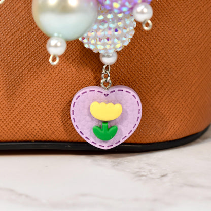 Whimsical pastel bag charm with vibrant beaded design, pearls, and heart flower charm. Handmade statement purse accessory and beaded keychain inspired by spring, coquette, and kawaii style. Ideal for totes, handbags, and gifts.