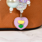 Whimsical pastel bag charm with vibrant beaded design, pearls, and heart flower charm. Handmade statement purse accessory and beaded keychain inspired by spring, coquette, and kawaii style. Ideal for totes, handbags, and gifts.