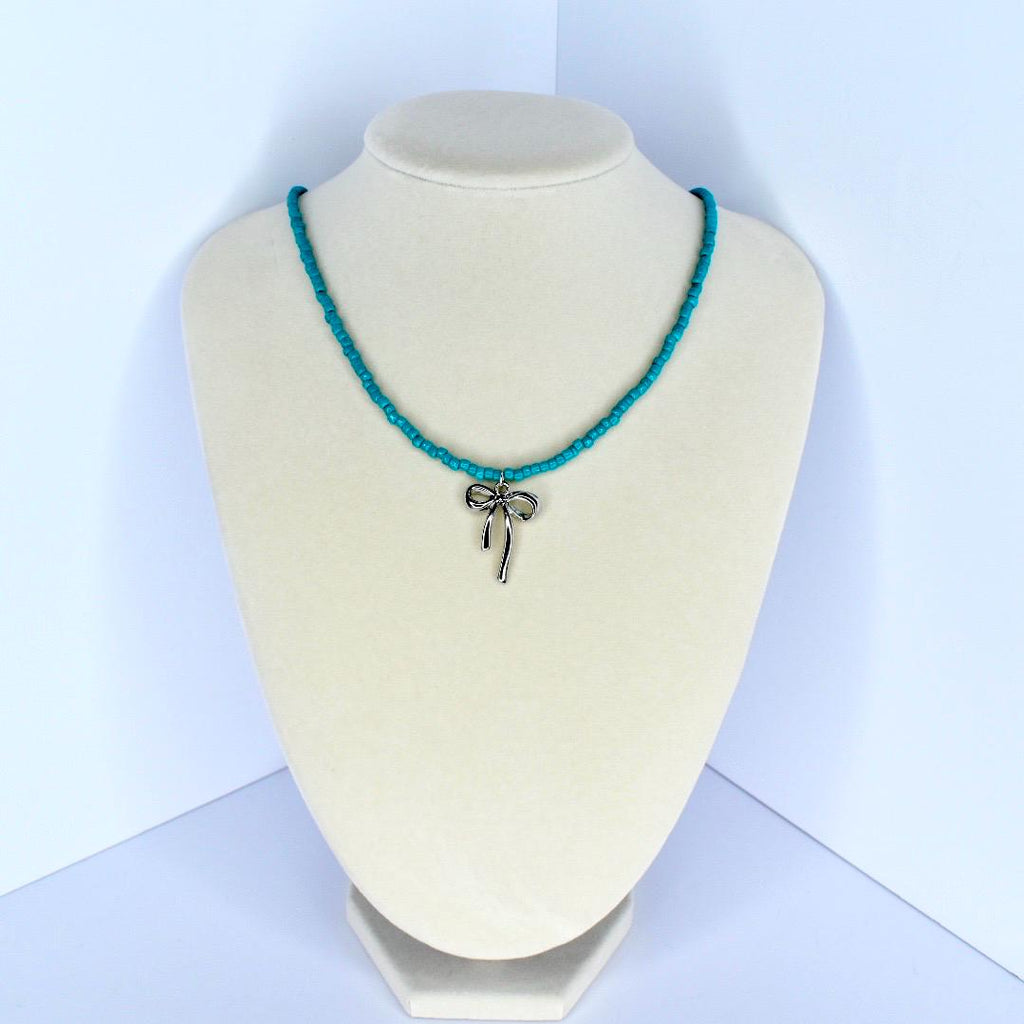 Handmade turquoise beaded necklace with delicate silver bow charm – feminine summer jewelry.