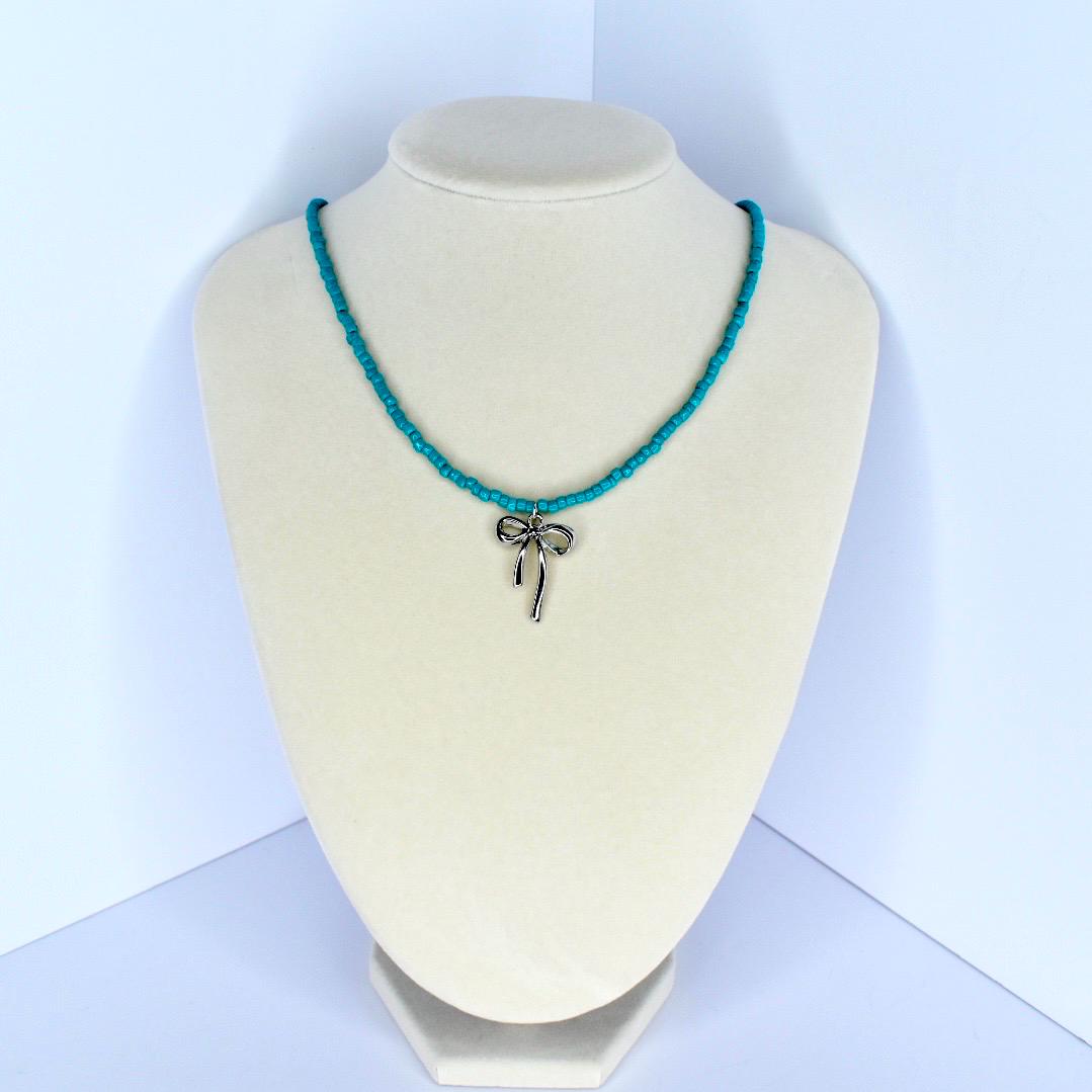 Handmade turquoise beaded necklace with delicate silver bow charm – feminine summer jewelry.