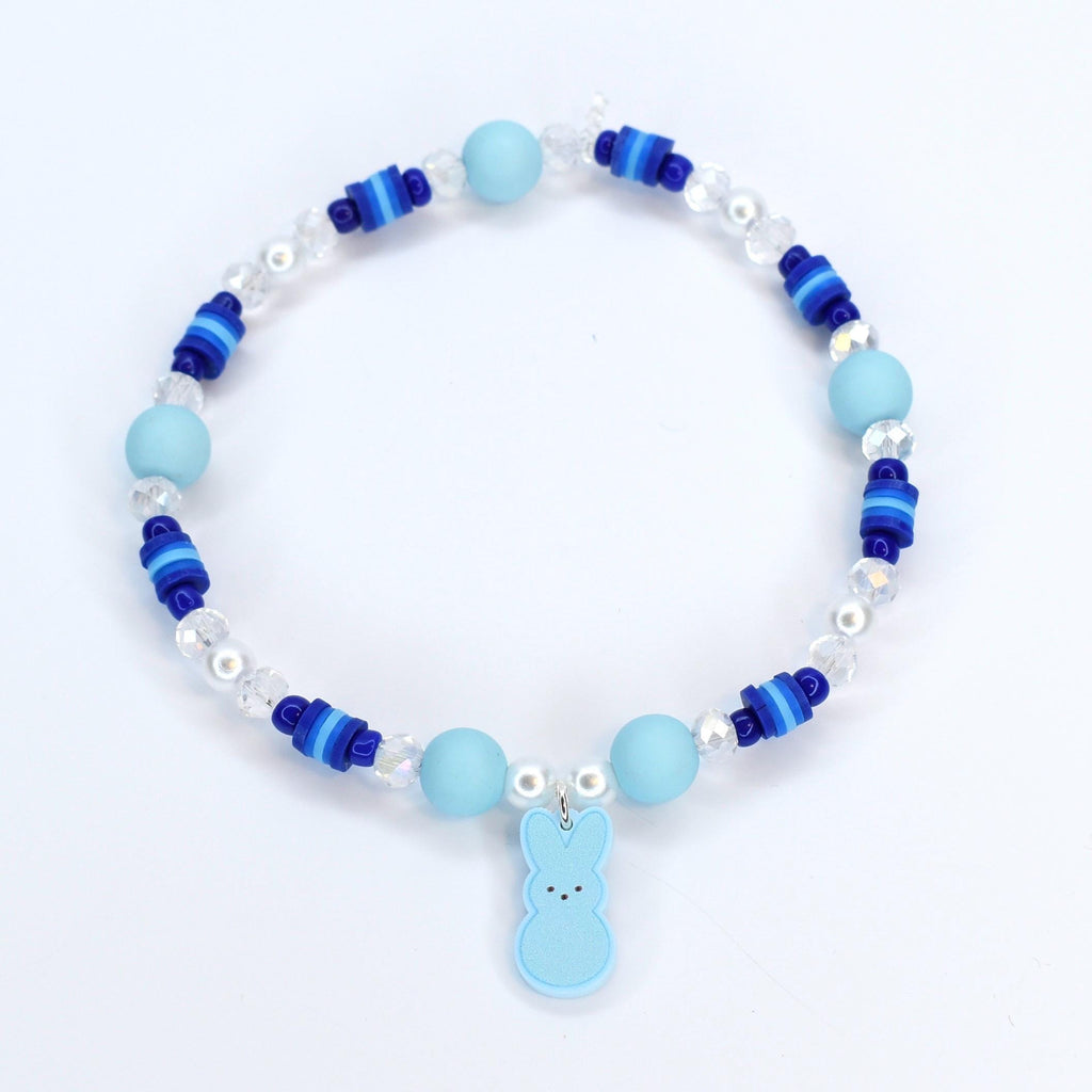 A bracelet with pastel blue and blue gradient heishi beads with crystal and pearl accent beads. A pastel blue PEEPS charm is the focal point of the bracelet.