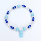 A bracelet with pastel blue and blue gradient heishi beads with crystal and pearl accent beads. A pastel blue PEEPS charm is the focal point of the bracelet.