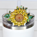 A decorative sunflower straw topper with yellow, orange, and green jewel-like accents. The sunflower is attached to a clear lid on a white tumbler. The topper adds a touch of sparkle and charm.
