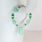 A beaded bracelet with a light green Peep charm. The bracelet features light green and clear beads, with a silver clasp. The bracelet is a spring-themed accessory.