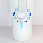 A light blue beaded bracelet with a bunny charm. The bracelet features light blue and dark blue beads, clear crystal beads, and a light blue bunny charm. The bracelet is displayed on a white mannequin.