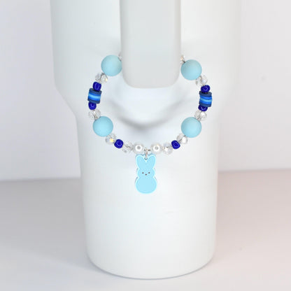 A light blue beaded bracelet with a bunny charm. The bracelet features light blue and dark blue beads, clear crystal beads, and a light blue bunny charm. The bracelet is displayed on a white mannequin.