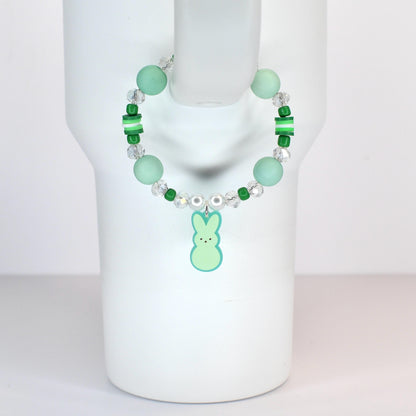 A beaded handle bracelet featuring mint green and clear beads, with a light green bunny charm. The bracelet includes larger round beads, smaller green beads, and clear crystal-like beads. The bunny charm has a light green body and a darker green outline.
