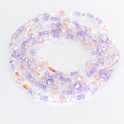 Strands of beaded jewelry in shades of clear, pink, and lavender. The beads are various shapes and sizes, including round and oval. The jewelry is arranged in a circular pattern, with the beads reflecting light.
