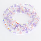 Strands of beaded jewelry in shades of clear, pink, and lavender. The beads are various shapes and sizes, including round and oval. The jewelry is arranged in a circular pattern, with the beads reflecting light.