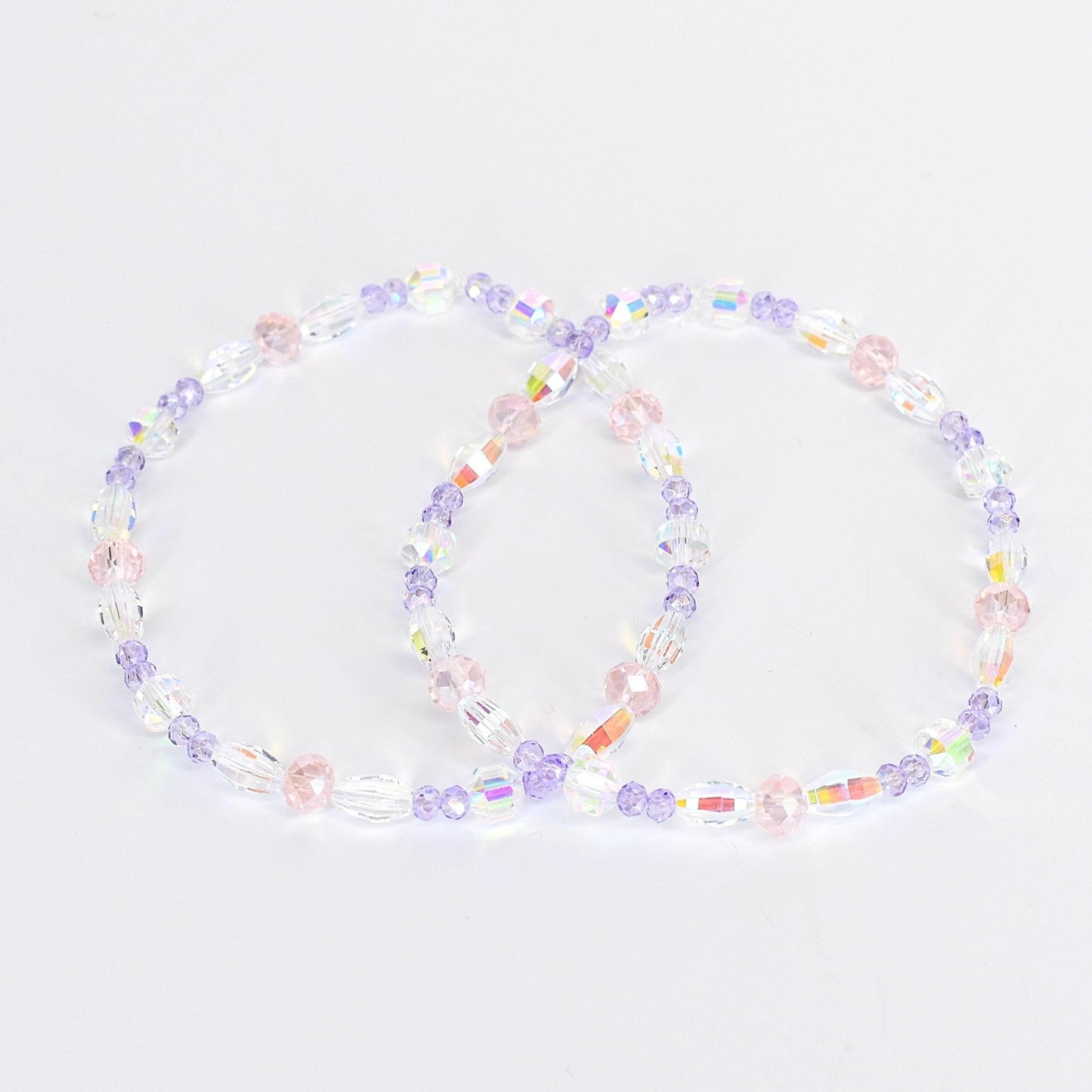 Two beaded bracelets. Each bracelet features a mix of clear, iridescent, pink, and purple beads. The beads are strung together to form a circular shape. The bracelets are displayed on a white background.