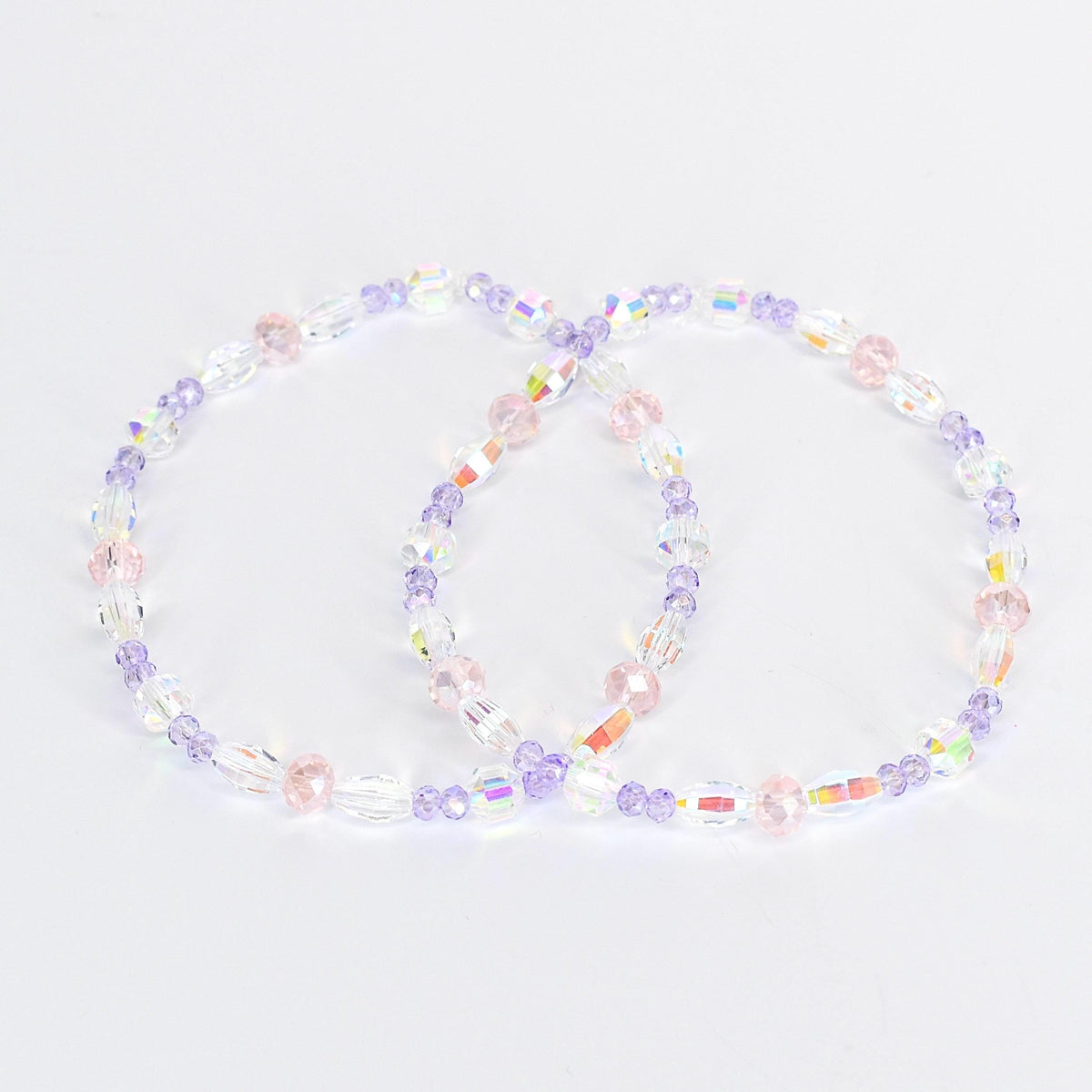 Two beaded bracelets. Each bracelet features a mix of clear, iridescent, pink, and purple beads. The beads are strung together to form a circular shape. The bracelets are displayed on a white background.