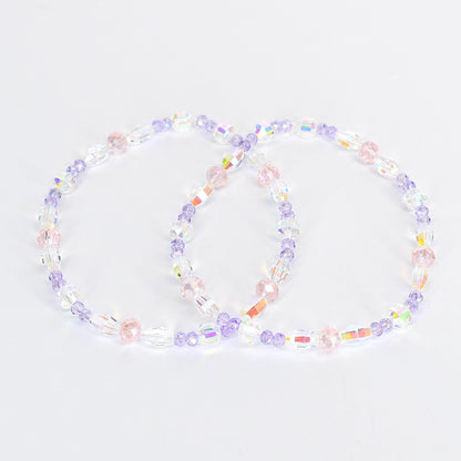 Two beaded bracelets. Each bracelet features a mix of clear, iridescent, pink, and purple beads. The beads are strung together to form a circular shape. The bracelets are displayed on a white background.