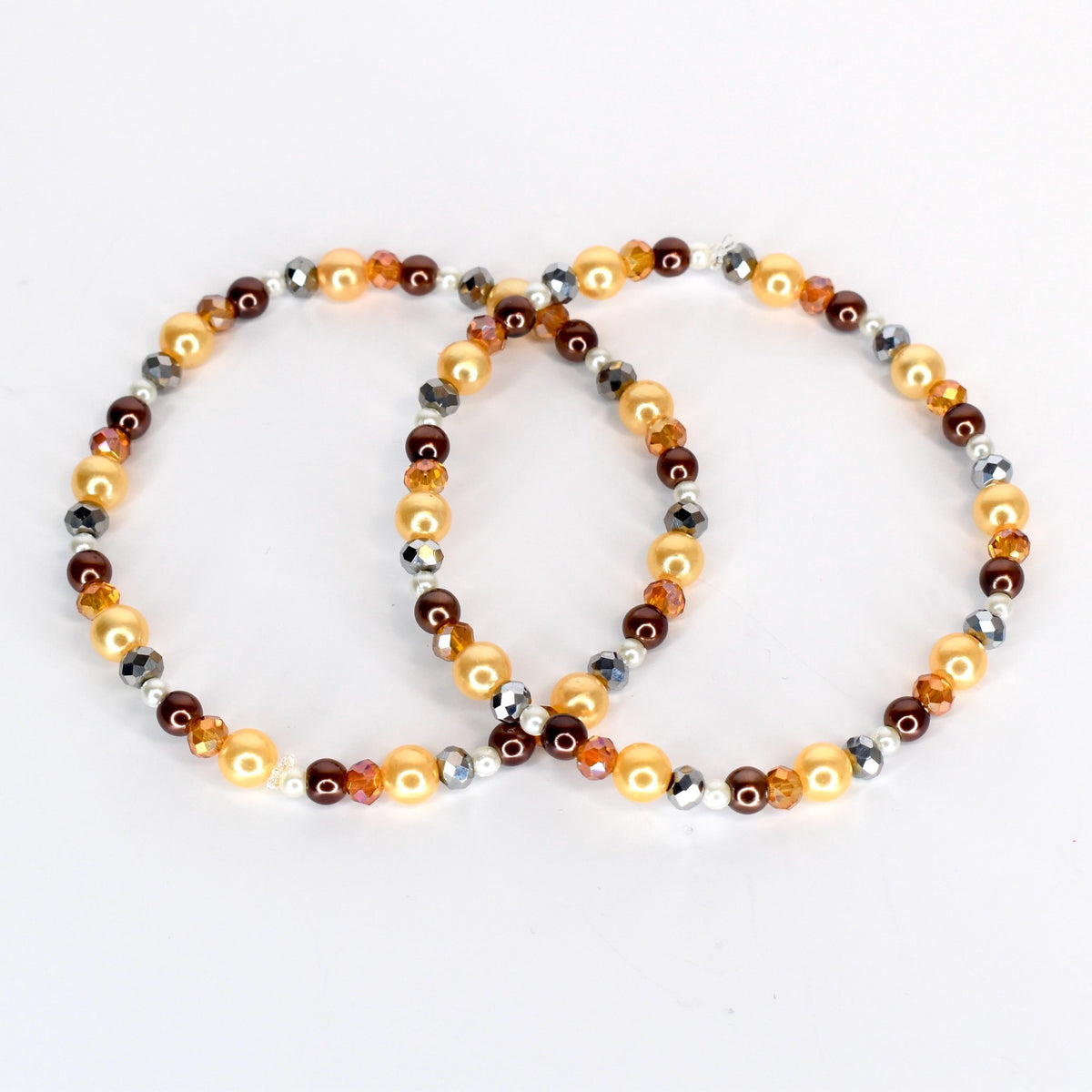 Two beaded bracelets. One bracelet features golden, brown, and silver beads. The other bracelet has a similar design, with golden, brown, and silver beads. The bracelets are on a white background.