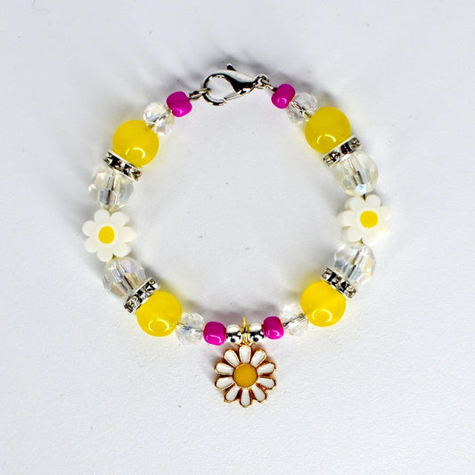A beaded tumbler handle bracelet with yellow, clear, and fuchsia beads. The bracelet features white daisy-shaped beads and a gold-colored daisy charm. The bracelet is secured with a silver-colored clasp.