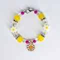 A beaded tumbler handle bracelet with yellow, clear, and fuchsia beads. The bracelet features white daisy-shaped beads and a gold-colored daisy charm. The bracelet is secured with a silver-colored clasp.