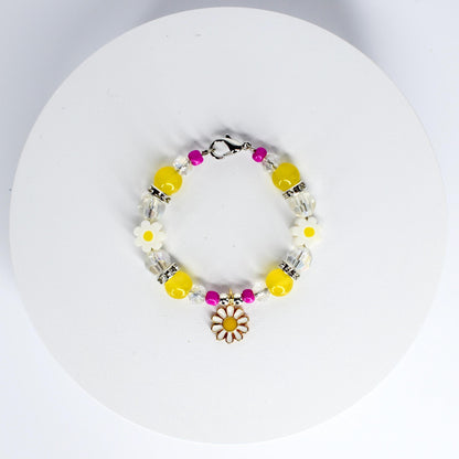 A beaded tumbler handle bracelet featuring yellow, clear, and pink beads. The bracelet includes white daisy-shaped beads and a daisy charm. The beads are strung on a silver-colored chain with a clasp.