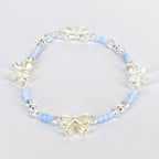A delicate bracelet featuring a repeating pattern of light blue beads, clear crystal beads, and ivory-colored bow charms. The bracelet is strung on an elastic band, creating a flexible and comfortable fit. The bow charms add a touch of elegance.