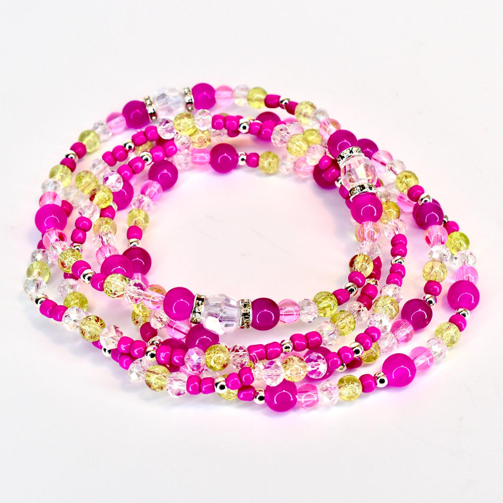 A collection of beaded bracelets in shades of pink, yellow, and clear. The beads are strung together with silver-colored accents. The waist beads are arranged in a circular pattern against a white background.