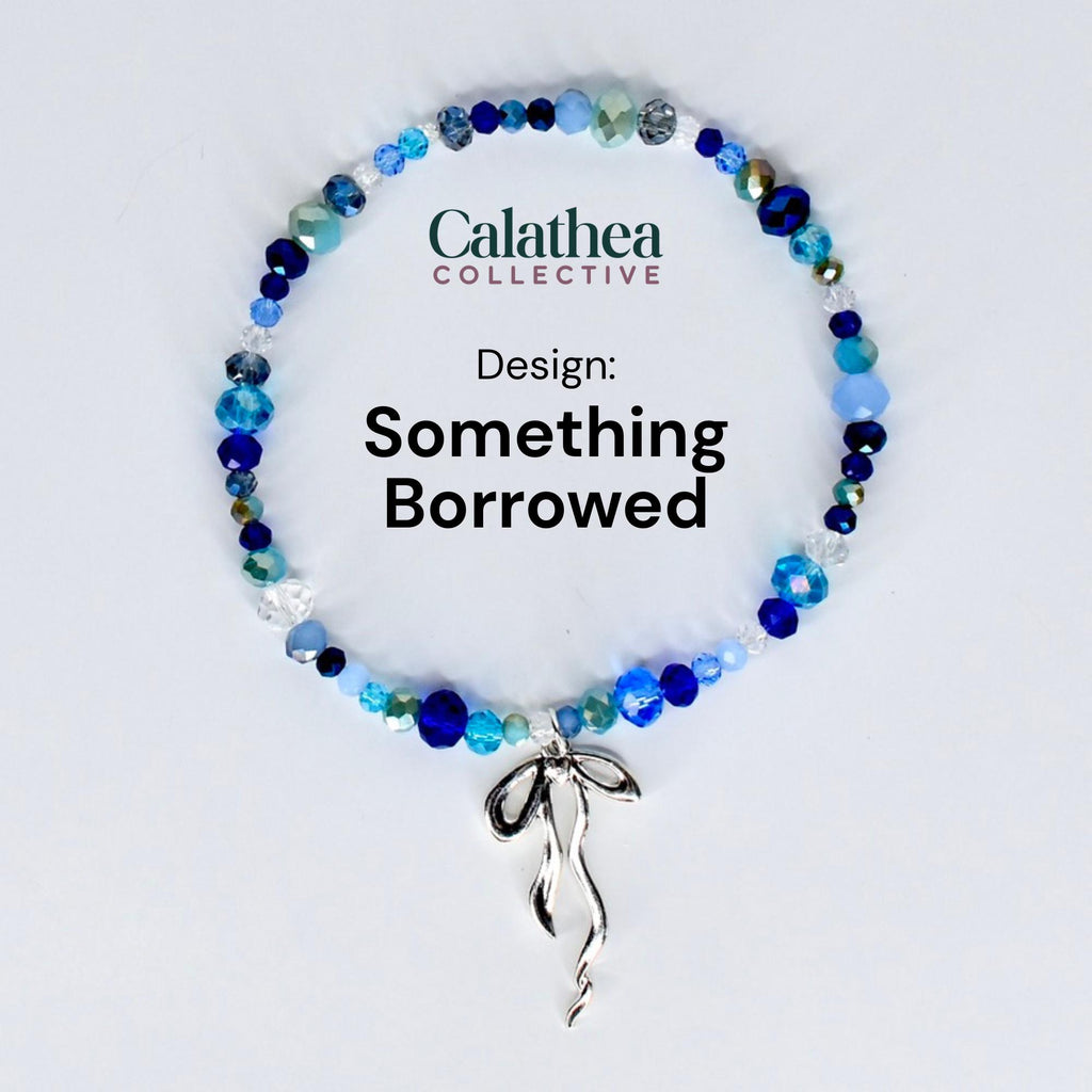A beaded bracelet with a variety of blue and clear beads. The bracelet has a silver-colored bow charm. The text "Calathea Collective" and "Design: Something Borrowed" are displayed on the image.