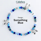 A beaded bracelet with a variety of blue beads and silver bow charms. The bracelet is labeled "Something Blue" and is from the Calathea Collective.