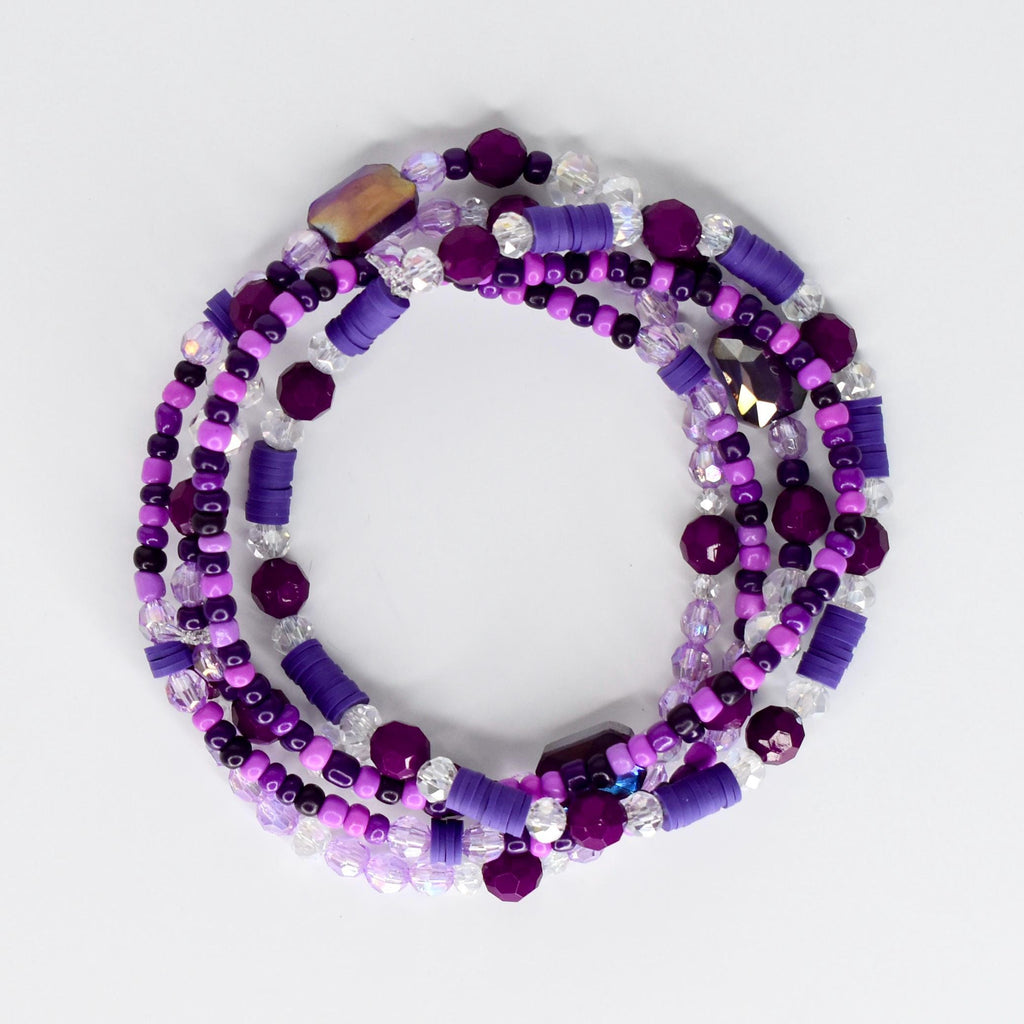 A collection of purple and clear beaded bracelets. The bracelets feature a variety of bead shapes and sizes, including round, cylindrical, and faceted beads. The color palette includes shades of purple and clear, with some iridescent accents.
