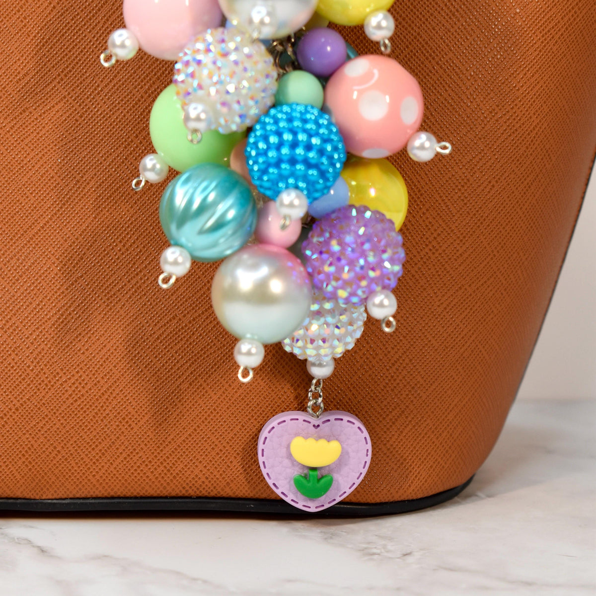 Pastel spring bag charm with colorful beaded cluster, pearl accents, and heart flower charm. Handmade purse charm and statement keychain in pink, yellow, blue, and purple. Cute pastel accessory and gift for her.