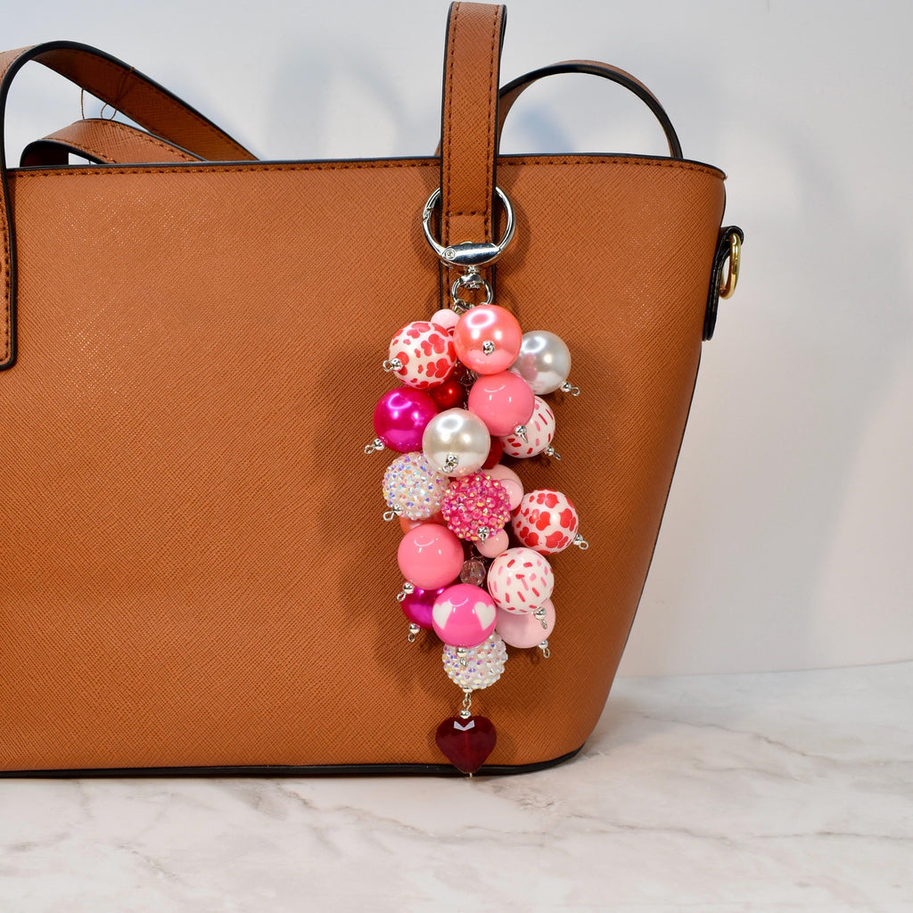 Romantic pink bag charm with vibrant beaded cluster, pearl details, and heart pendant. Handmade statement purse accessory and beaded keychain inspired by Valentine, coquette, and feminine style. Perfect gift for her or cute tote charm.