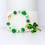 A St. Patrick's Day tumbler handle bracelet featuring green shamrock charms and beads. The bracelet includes green, white, and gold accents, with a large shamrock pendant.