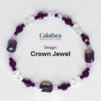A beaded bracelet with the text "Calathea Collective" and "Design: Crown Jewel." The bracelet features a mix of purple, clear, and iridescent beads. The design includes faceted and round beads.