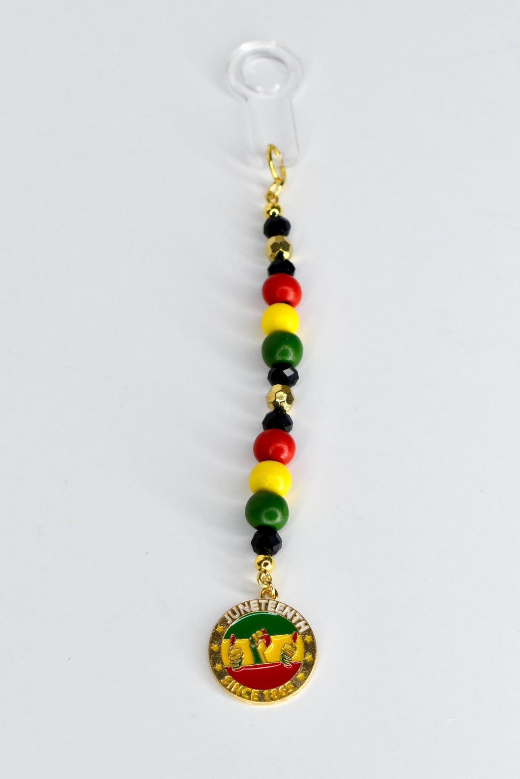 A Juneteenth-themed straw charm with a clear plastic straw adapter at the top. The charm features a string of red, yellow, green, and black beads, and a gold-colored pendant with the words "Juneteenth Since 1865" and a graphic of two hands.