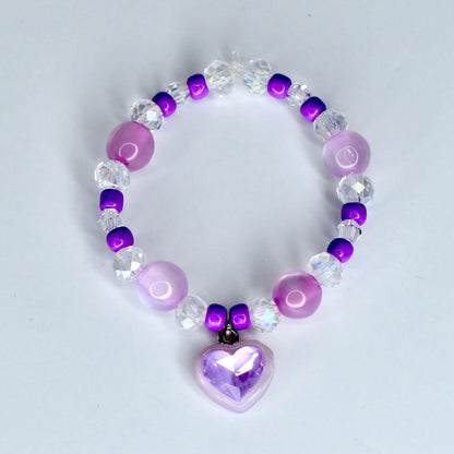 A beaded 17cm monster doll necklace featuring a heart charm. The necklace is composed of various beads in shades of purple, clear, and white. The heart charm is a light purple color and has a faceted design.