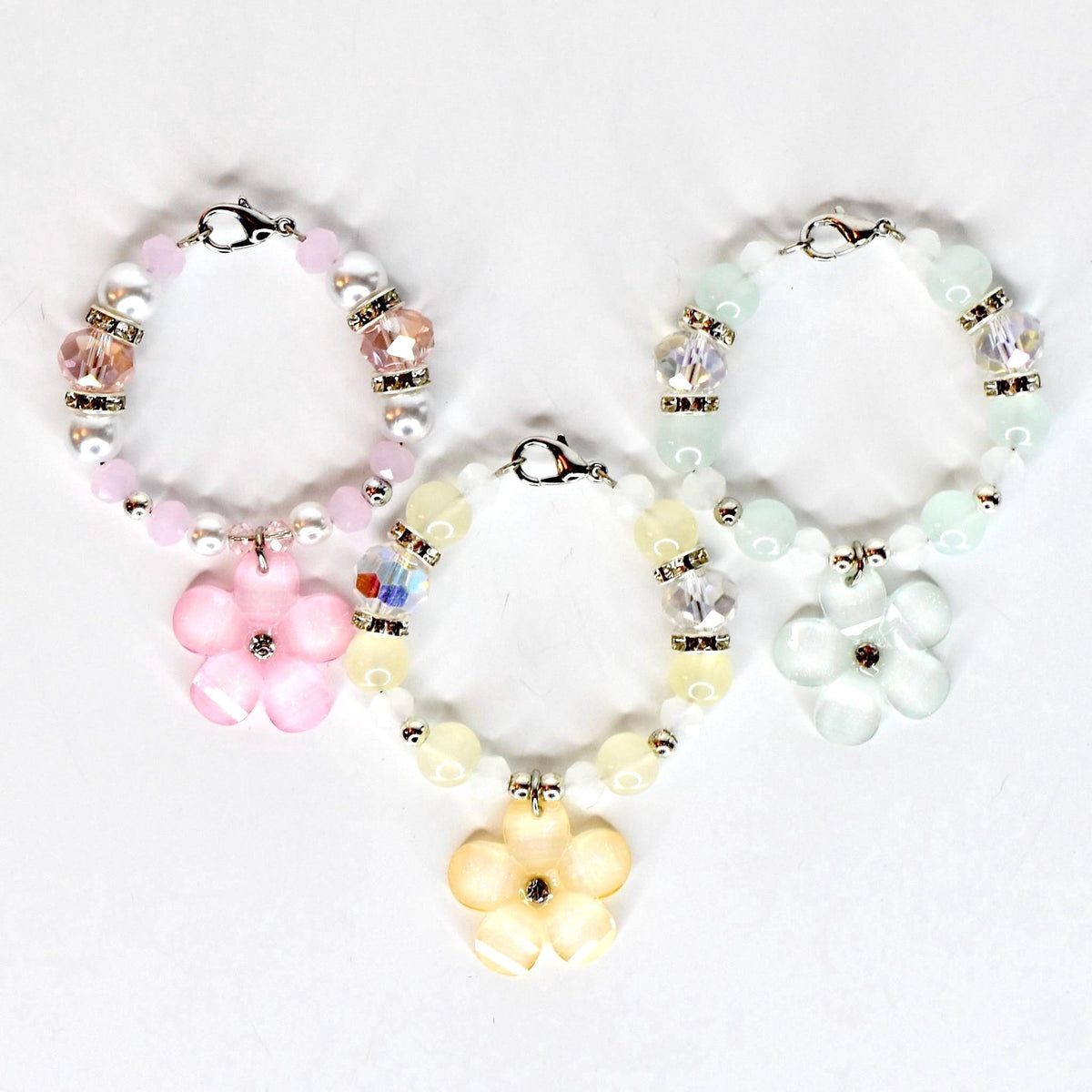 Three beaded tumbler handle bracelets with flower pendants. The bracelets feature a variety of beads in pink, yellow, and green, with silver-tone accents. Each bracelet has a flower-shaped pendant in a matching color.