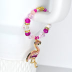 A beaded tumbler handle bracelet with a gold and pink rhinestone flamingo charm and pink and clear crystal beads with gold accents.