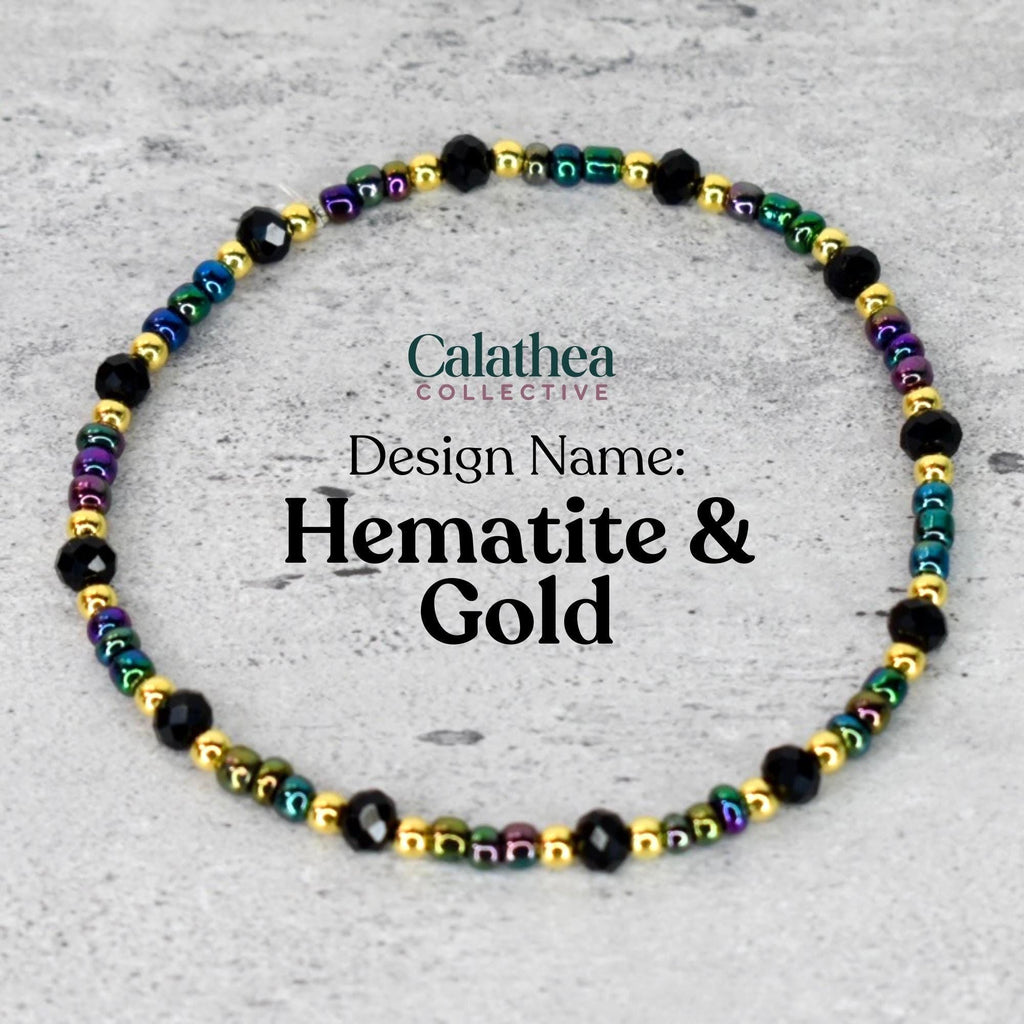 A beaded bracelet with the text "Calathea Collective" and "Design Name: Hematite & Gold". The bracelet features black, gold, and iridescent beads. The beads are strung together to form a circular shape.