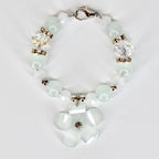 A delicate tumbler handle bracelet featuring a flower charm and a mix of light blue and white beads. The tumbler bracelet has a silver clasp and decorative crystal beads. The flower charm has a central crystal accent.