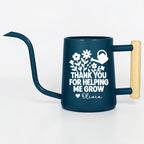 Navy blue metal gooseneck watering can with wood handle. The words 'thank you for helping me grow' with a floral design and small watering can is on the side of the watering can in white and the name 'Olivia' is written under the design with a small heart next to the name.